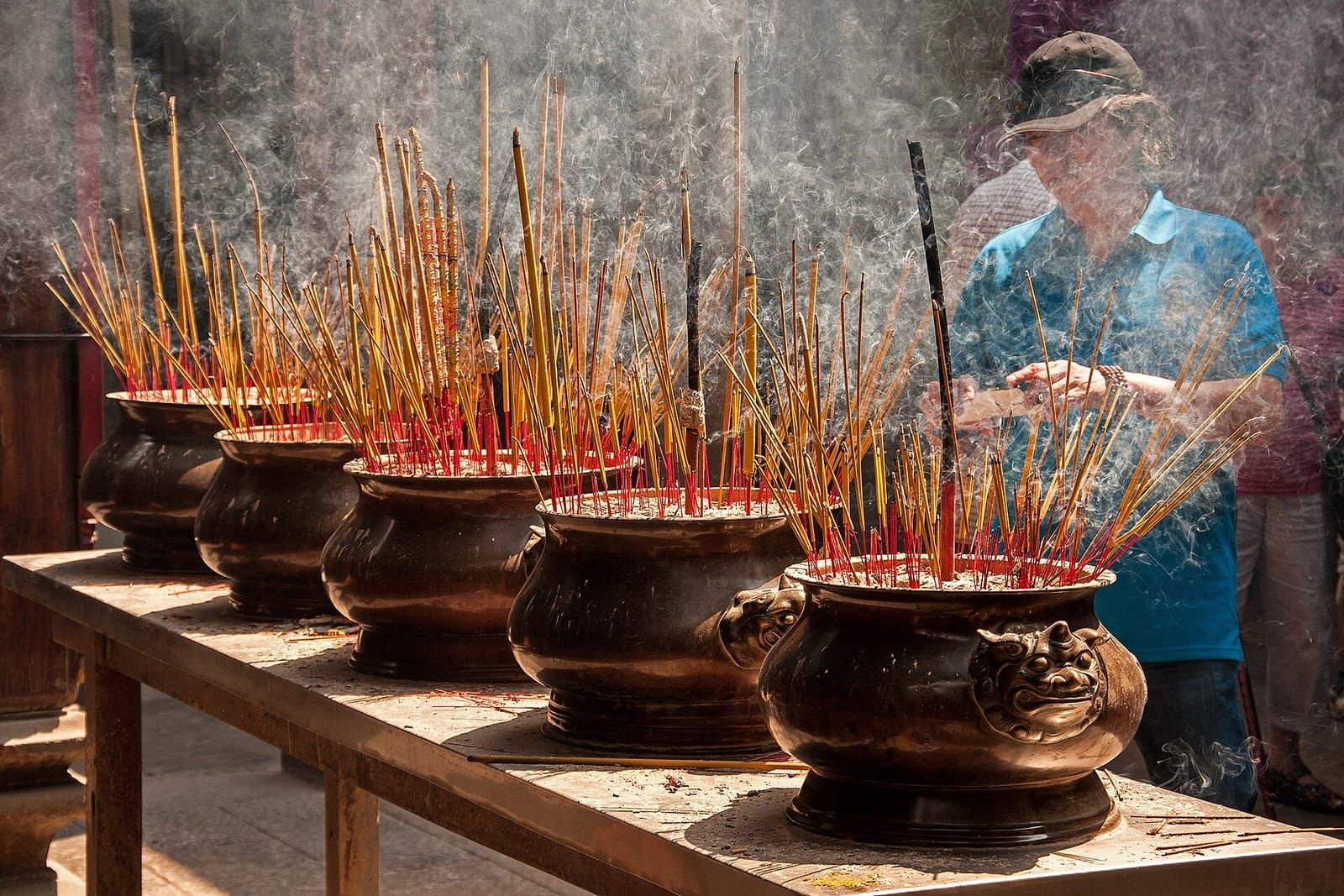 Nhang cháy nghi ngút trên hàng lư hương đồng đặt trước bàn thờ trong ngôi đền Việt Nam